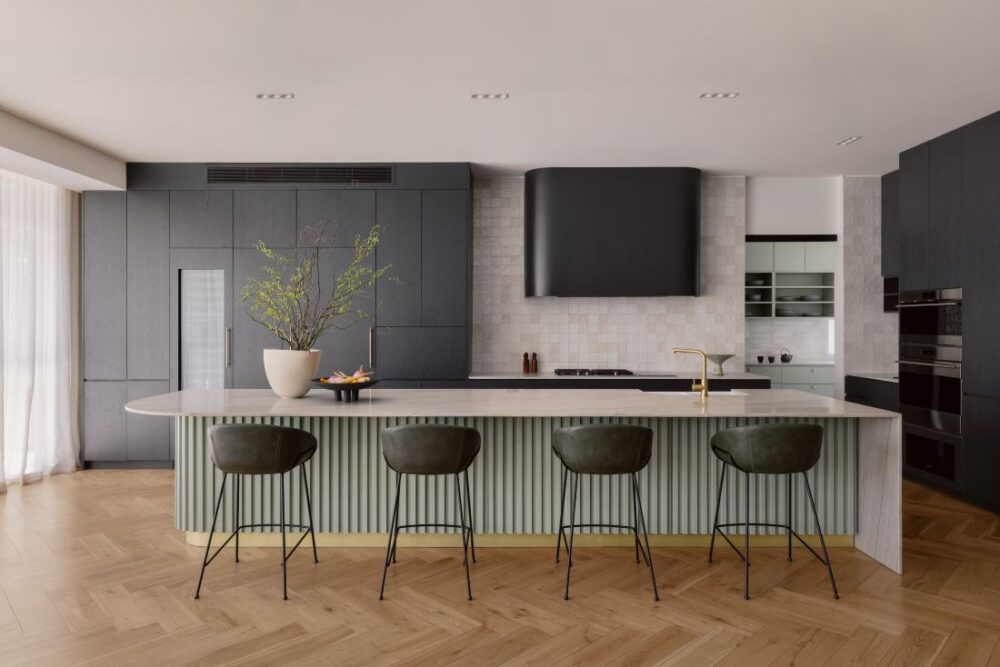 Modern kitchen featuring a textured green island, dark cabinetry, and Sub-Zero and Wolf appliances.