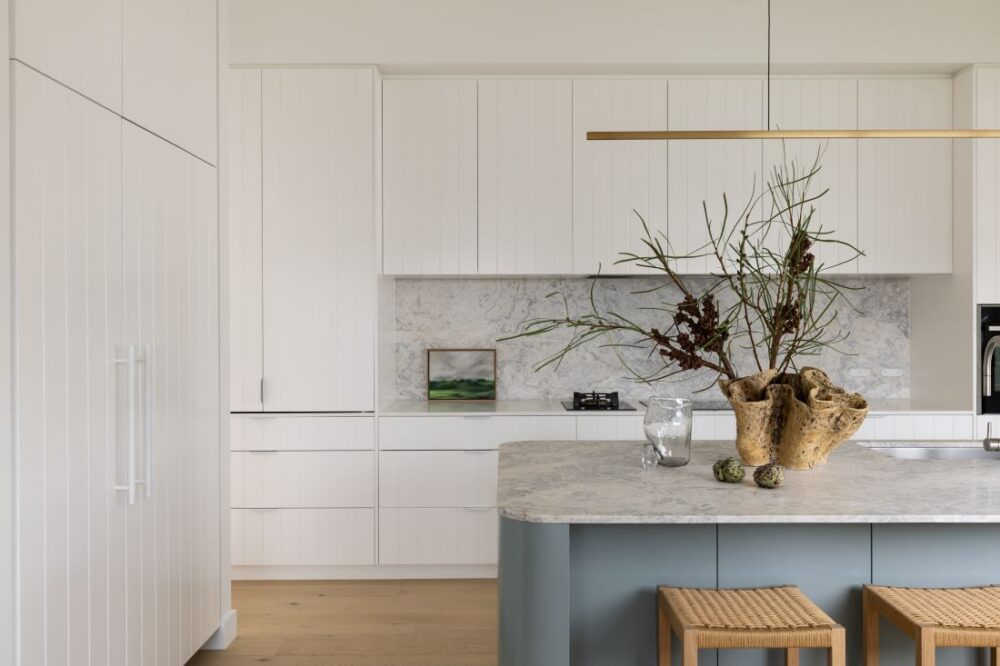 Modern kitchen with marble countertop, minimalist cabinetry, and striking décor by Annie Bowen at North Avoca Beach House.