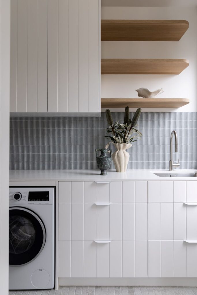 Modern laundry room with minimalist cabinetry, open shelving, and elegant décor by Annie Bowen at North Avoca Beach House.