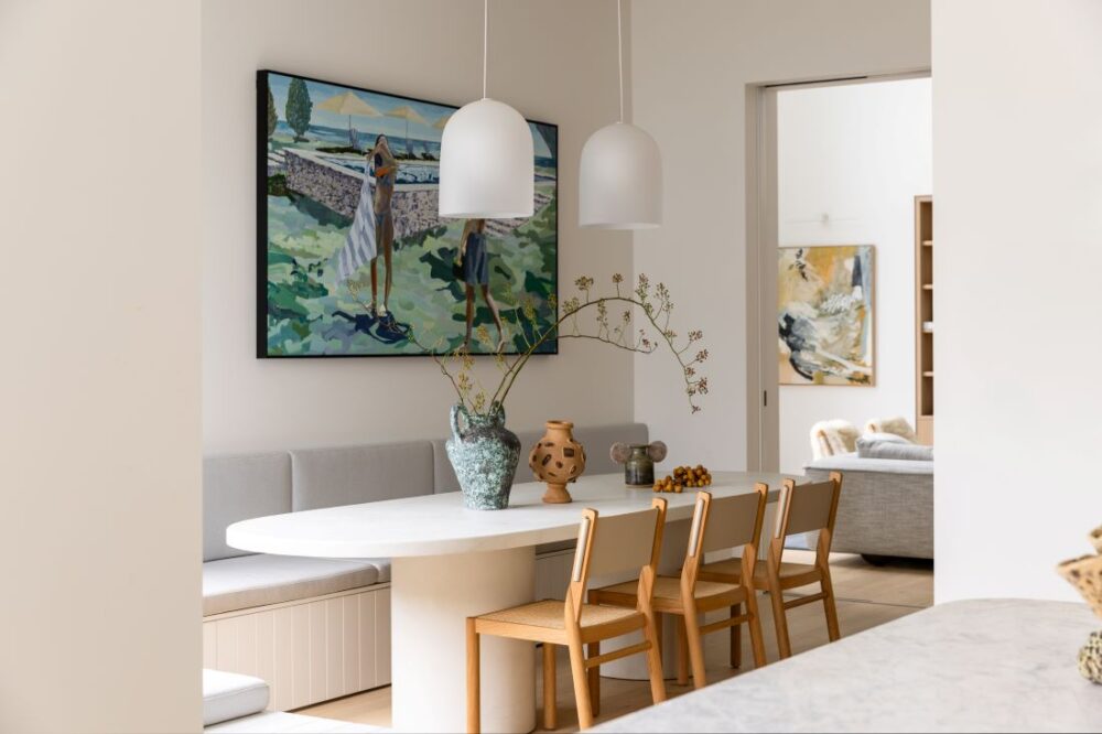Elegant dining room with modern table, lighting, and artwork by Annie Bowen at North Avoca Beach House.