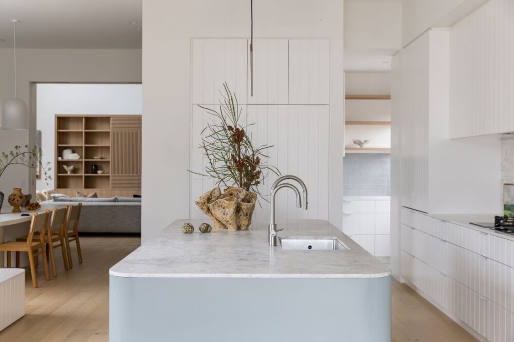 Modern kitchen island with marble countertop and minimalist design by Annie Bowen at North Avoca Beach House.