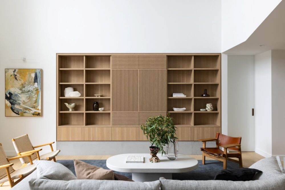 Modern living room featuring custom wooden shelving and contemporary furniture by Annie Bowen at North Avoca Beach House.