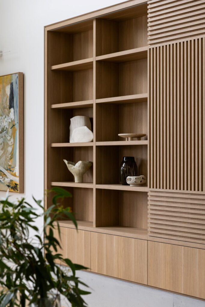 Modern wooden shelving with decorative pieces and natural textures by Annie Bowen at North Avoca Beach House.