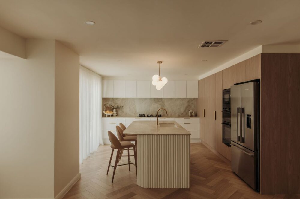 Elegant kitchen with island and modern fixtures by Sabina Christine Interiors at 48 Bilwara Avenue.