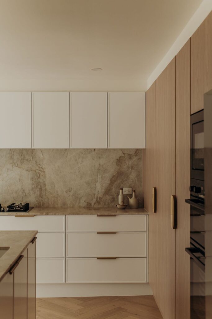 Clean-lined kitchen with modern cabinetry and elegant stone backsplash by Sabina Christine Interiors at 48 Bilwara Avenue.