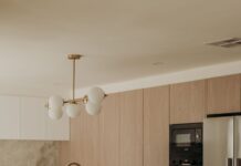 From a disjointed kitchen to a quietly considered haven Elegant kitchen island with ribbed details and modern lighting by Sabina Christine Interiors at 48 Bilwara Avenue.