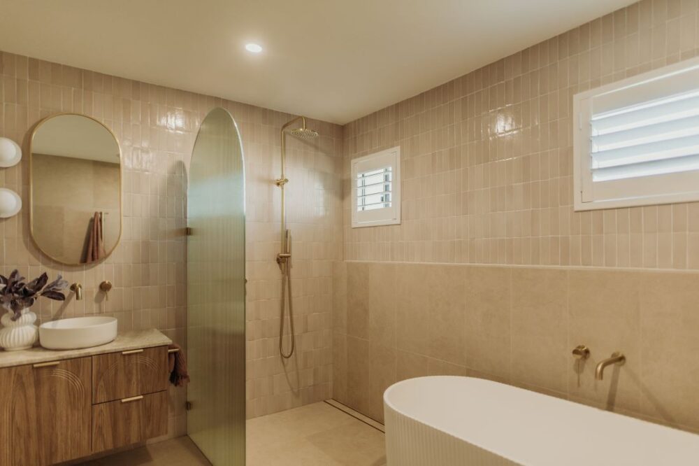 Stylish bathroom with a freestanding tub, shower, and modern fixtures by Sabina Christine Interiors at 48 Bilwara Avenue.