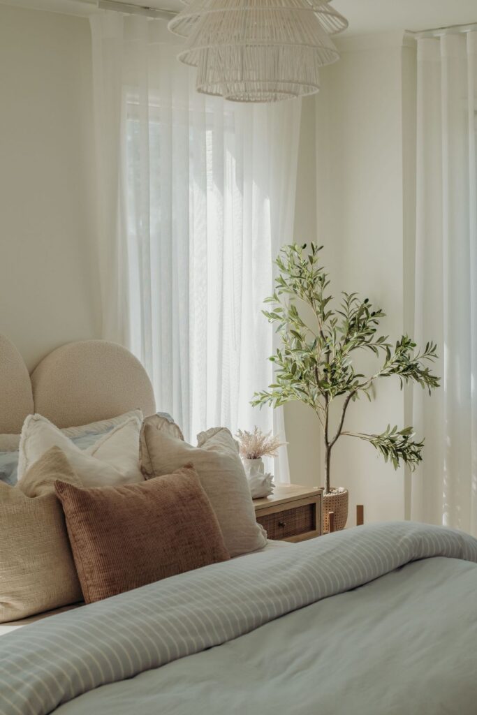 Inviting bedroom with soft bedding, natural light, and greenery by Sabina Christine Interiors at 48 Bilwara Avenue.