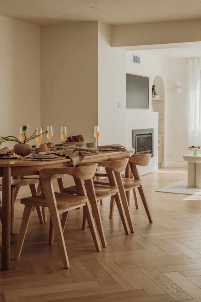 Beautiful dining area with wooden table, chairs, and soft décor by Sabina Christine Interiors at 48 Bilwara Avenue.