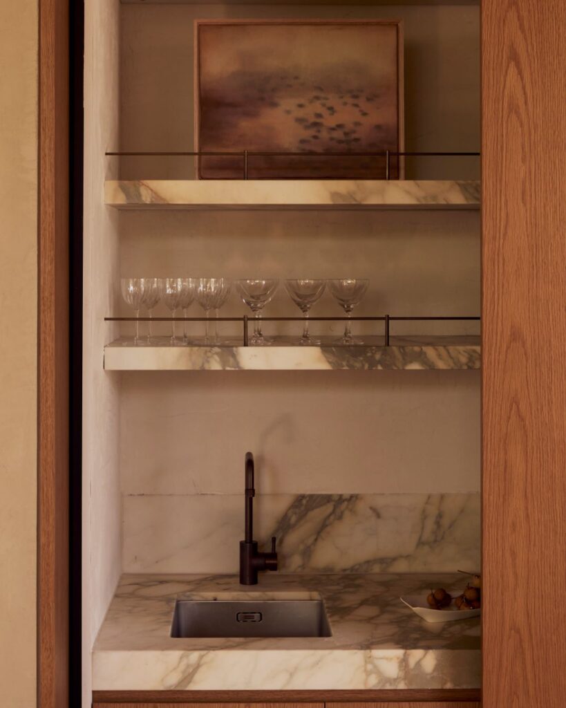Kitchenette with marble countertops and shelves