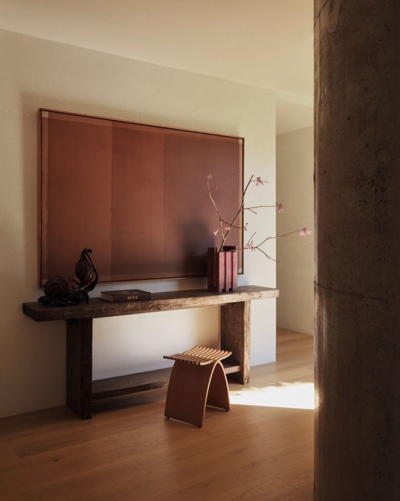 Wooden console table with artwork and sculptural vase