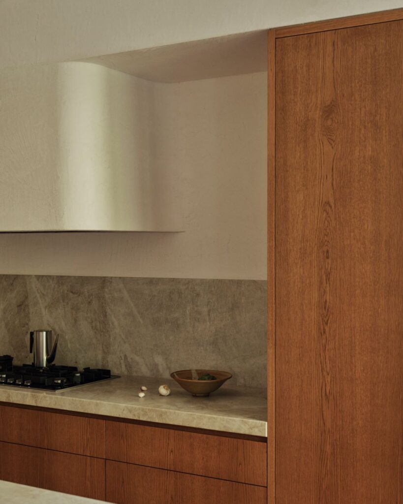 Close-up of marble countertop and wooden cabinetry in kitchen