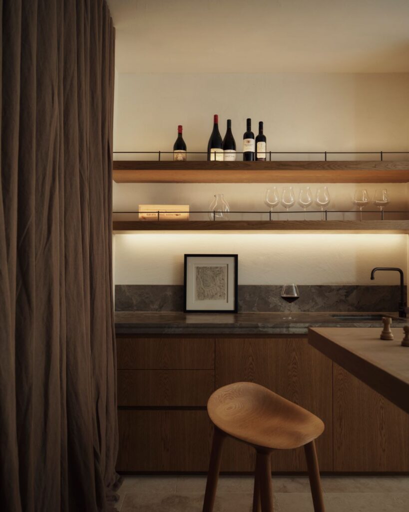 Kitchenette with wooden cabinetry, open shelves, and wine display