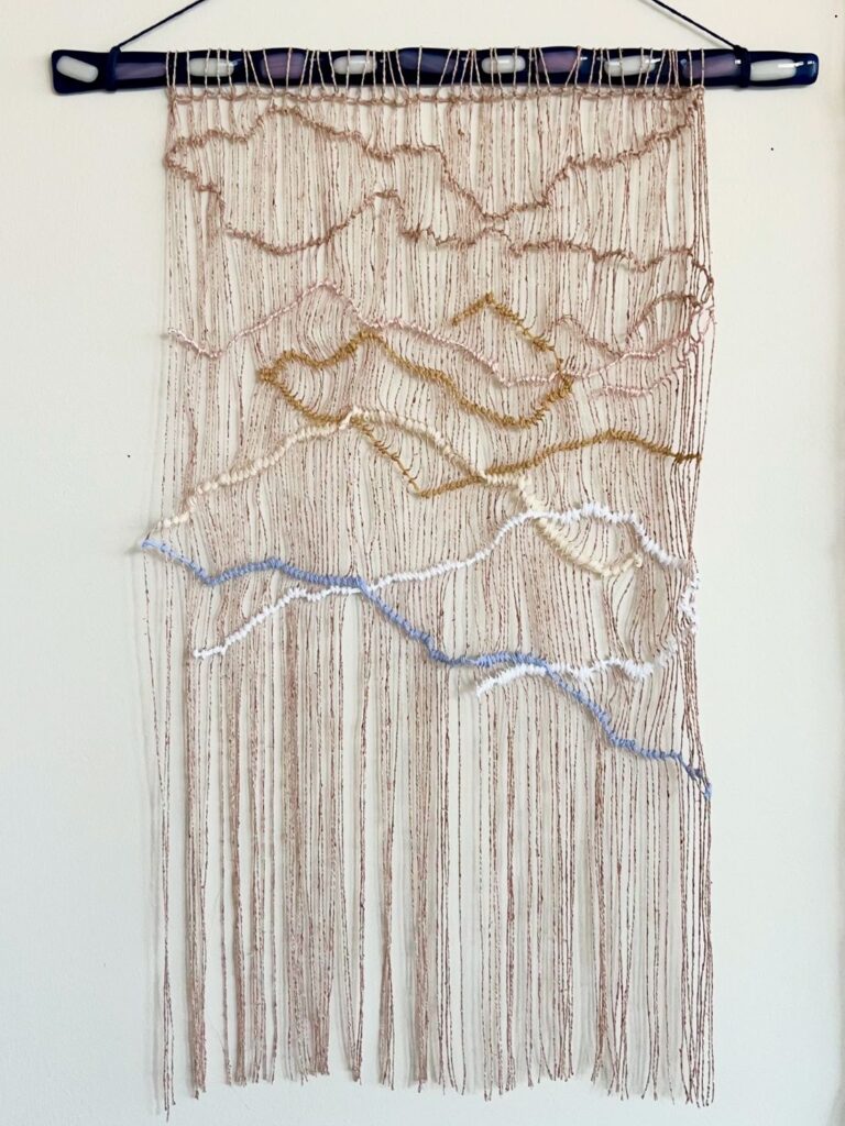Minimal woven wall hanging with layered thread landscape