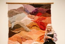 Large multicoloured woven wall hanging with textured fibre landscape