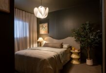 Bedroom with dark green walls, upholstered bed, and indoor plant