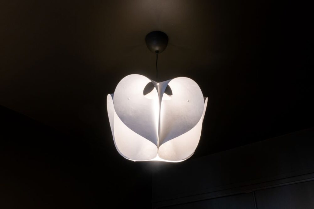 Modern sculptural pendant light in dark bedroom