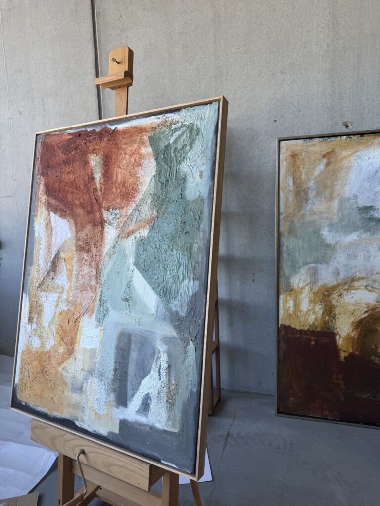 Close-up of textured abstract painting on easel in studio
