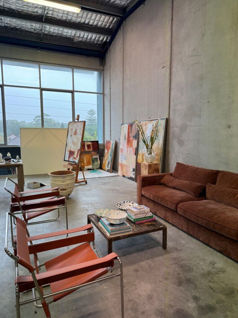 Contemporary studio space with abstract paintings, sofa, and seating area