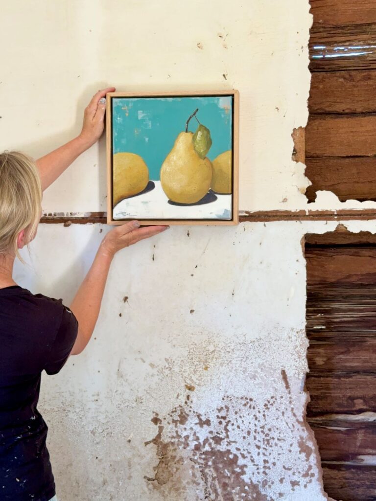 Framed painting of pears on teal background