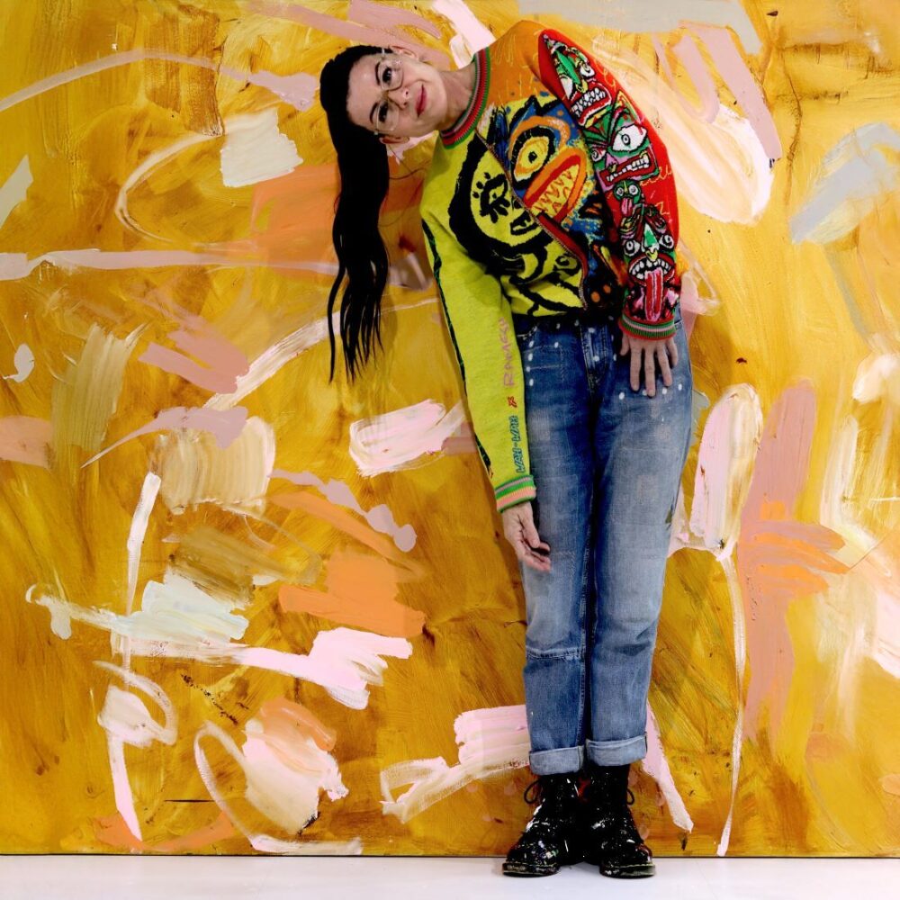Shayle Flesser posing before bright abstract painting