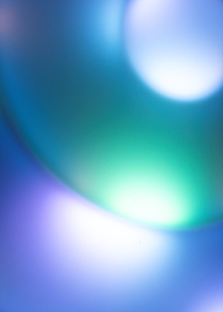 Close-up of an abstract sensory light artwork glowing in blue, green, violet and white