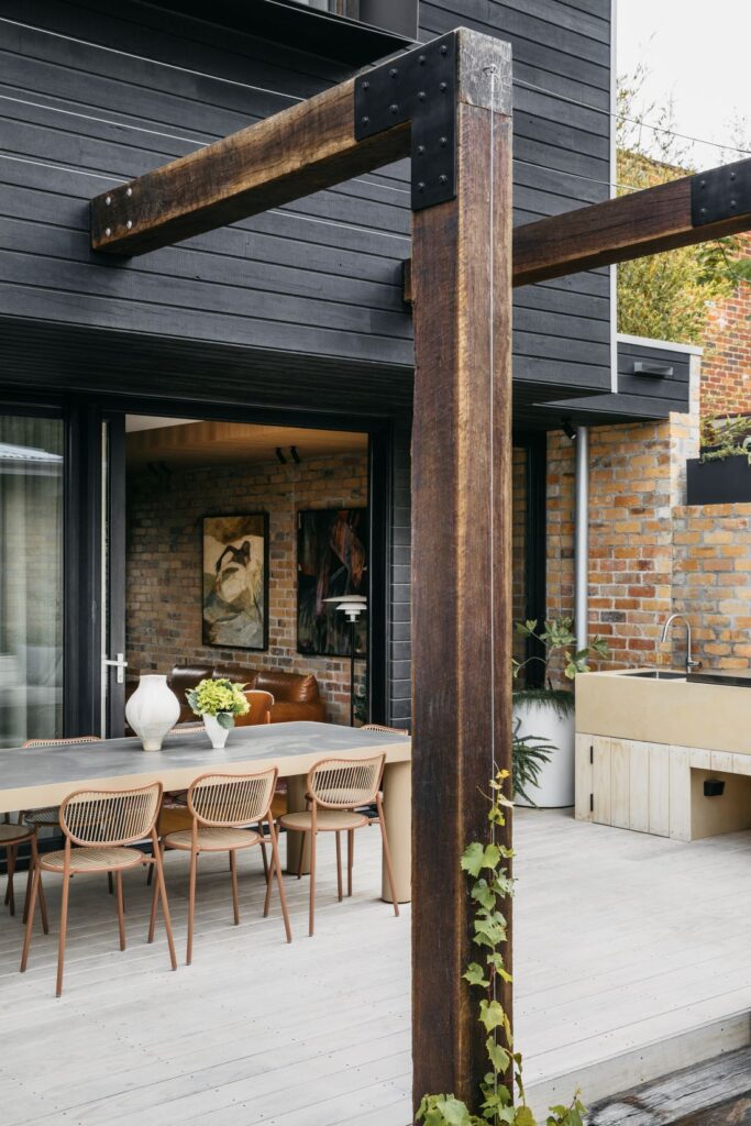 Modern outdoor dining space with timber and greenery
