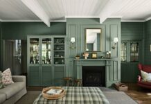 Disjointed to deeply connected: A warm country cottage redesigned Formal sitting room with deep green panelled walls, a matching fireplace, glazed cabinetry, plaid ottoman and red armchair