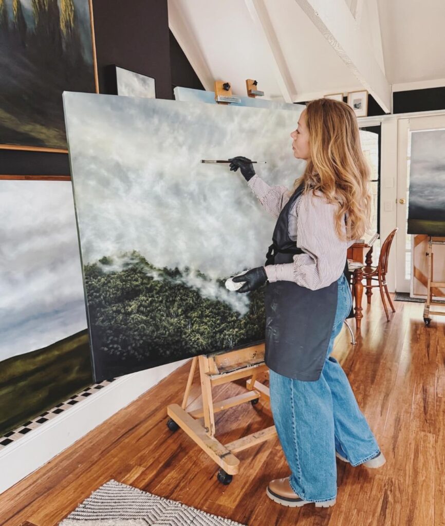 Artist Kelly Kondis painting atmospheric landscape in home studio