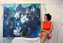 Where layers of colour capture feeling: Abstracts from Prue Frost Artist portrait with large blue abstract floral painting