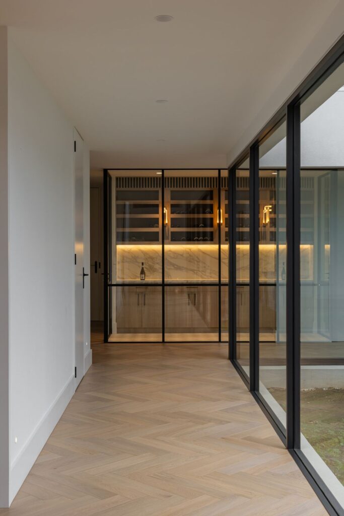 Hallway perspective to illuminated wine cellar in Boronia House