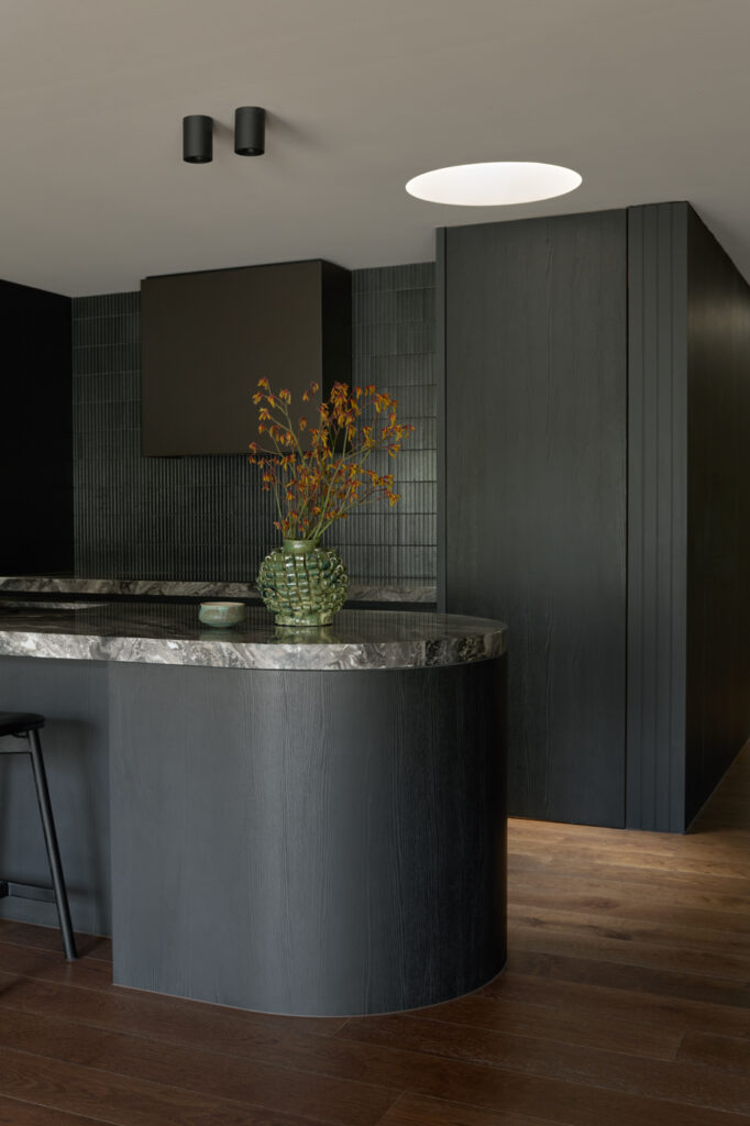 Black kitchen with curved island