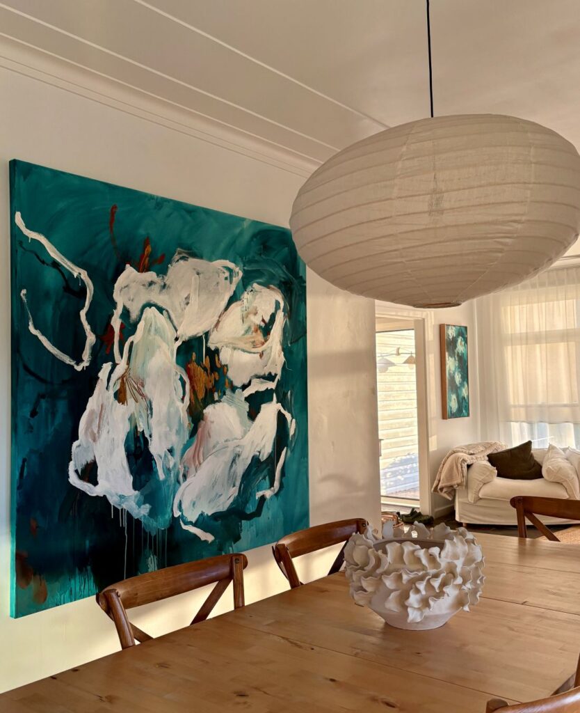 Large teal floral artwork in modern dining room