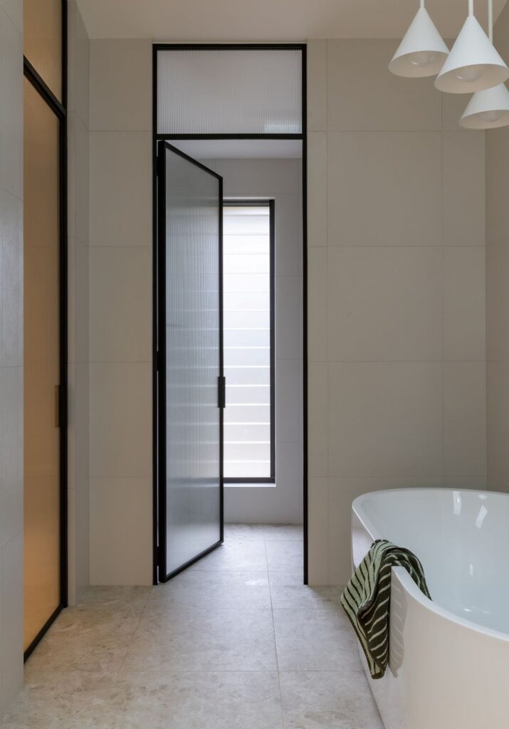 Luxury bathroom layout with reeded glass doors
