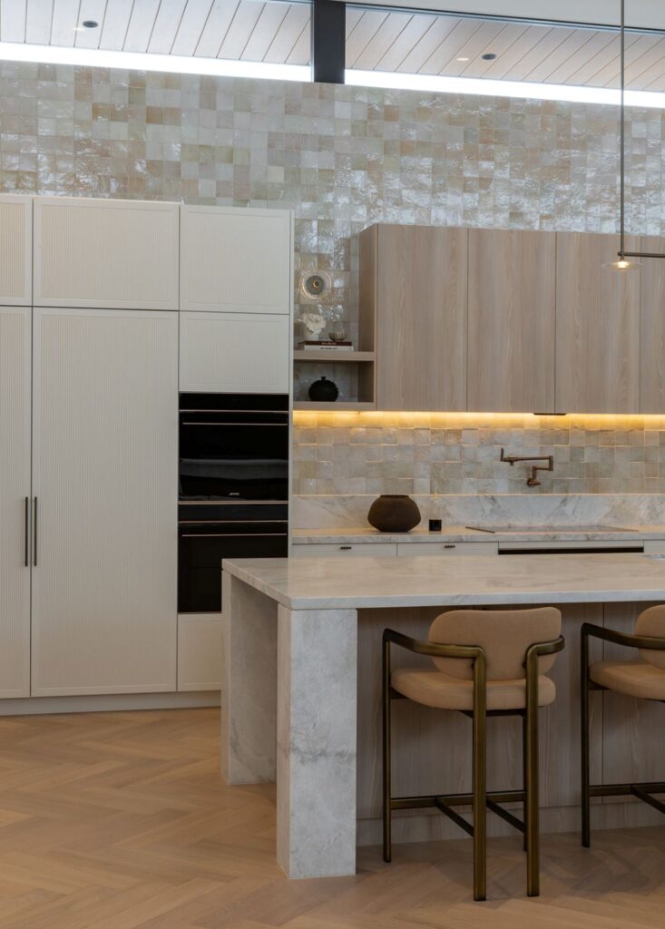 Marble kitchen island with brass barstools in Glenorie home