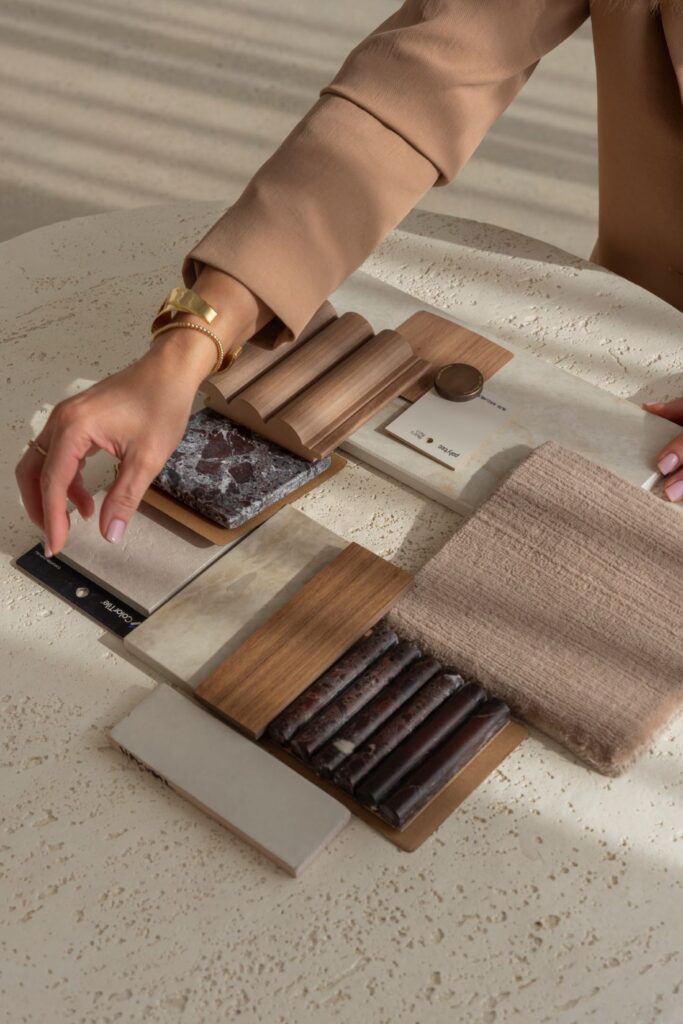 Material samples including stone, timber, tile and fabric arranged on a table during renovation planning.
