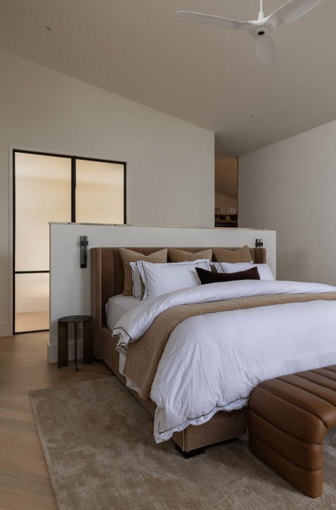 Master bedroom suite with velvet bed and reeded glass