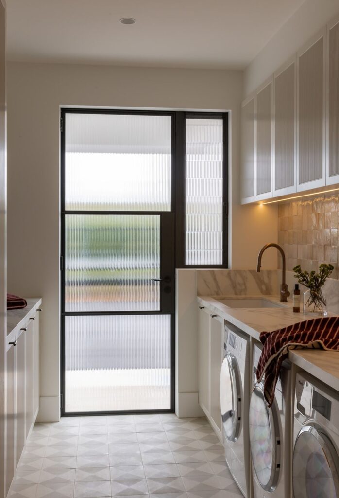Modern laundry room with reeded glass door