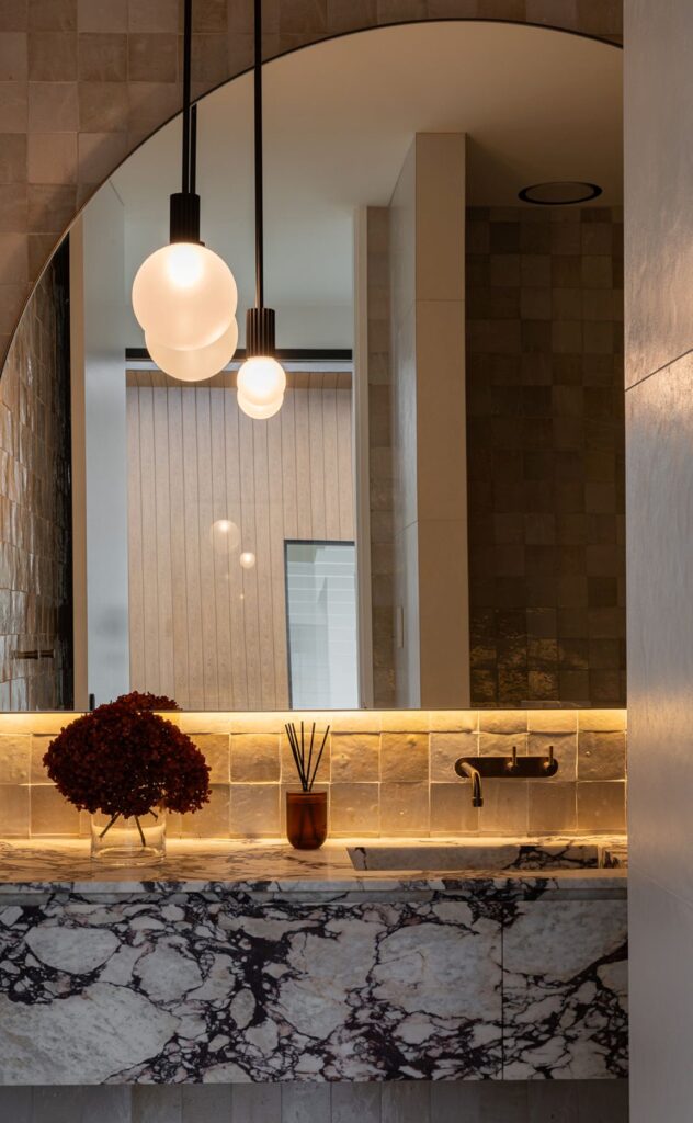 Powder room vanity with dramatic marble and zellige tiles