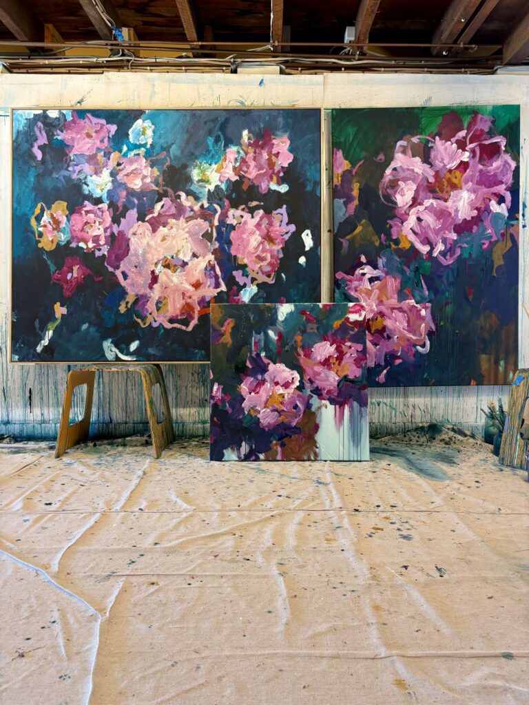 Vibrant pink floral paintings displayed in studio space
