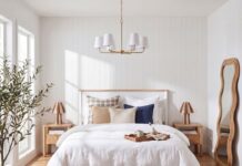 The secret to getting bedside table proportions right Bright bedroom featuring a white bed, matching wooden bedside tables, bedside lamps, neutral bedding, pendant light, timber flooring and woven rug.