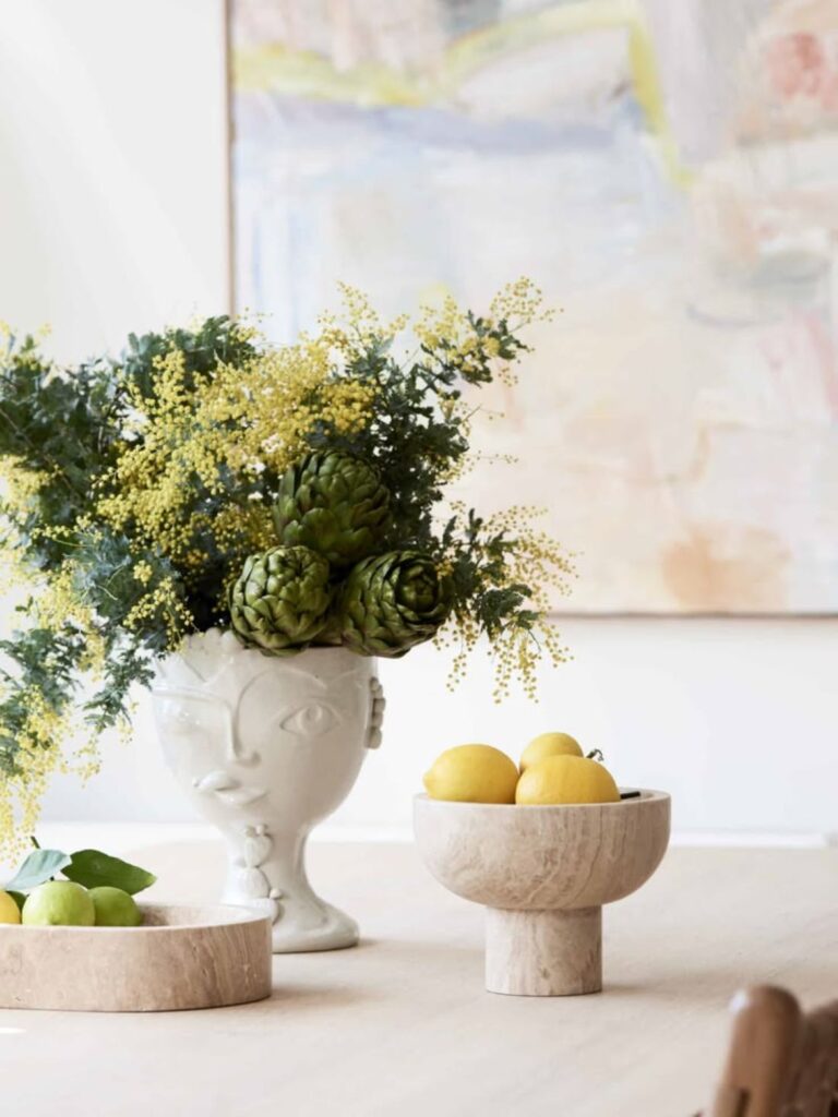 Wattle and artichoke arrangement in ceramic face vase